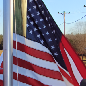 An american flag being raised in a rural community